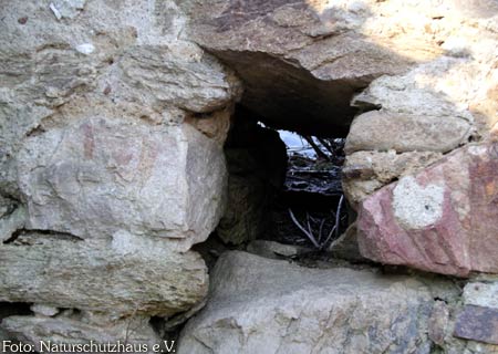 man kann durch ein Loch in der Mauer hindurchgucken