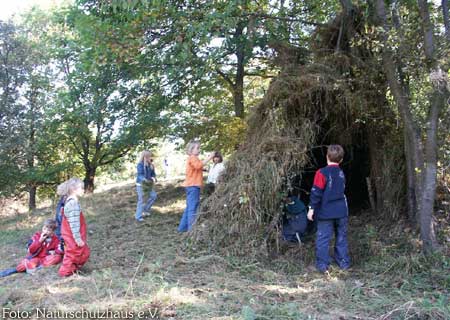 Kinder bauen ein Graszelt